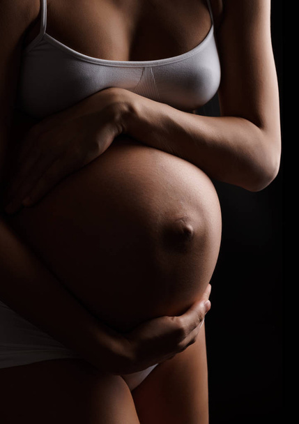 Close-up of pregnant woman holding her belly - Foto, Bild