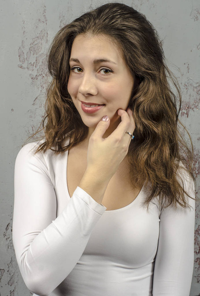  Portrait of a young brown-haired woman with a romantic curly hair in a white blouse  - Foto, Bild