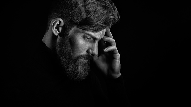 Young handsome bearded man with  beard and stylish haircut think - 写真・画像