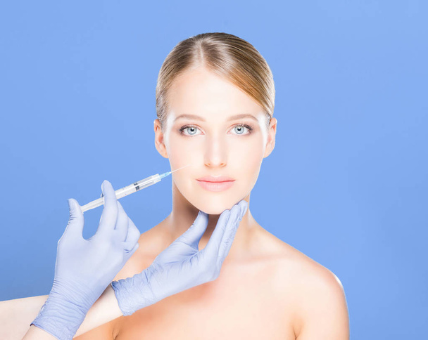 Doctor making injection into face of woman - Φωτογραφία, εικόνα