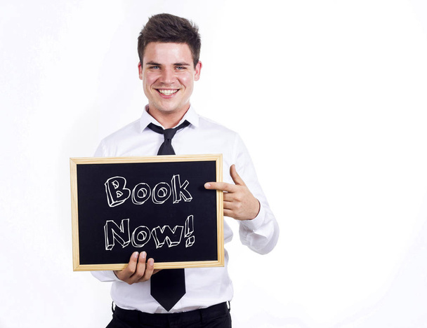 Book Now! - Young smiling businessman holding chalkboard with te - Photo, Image