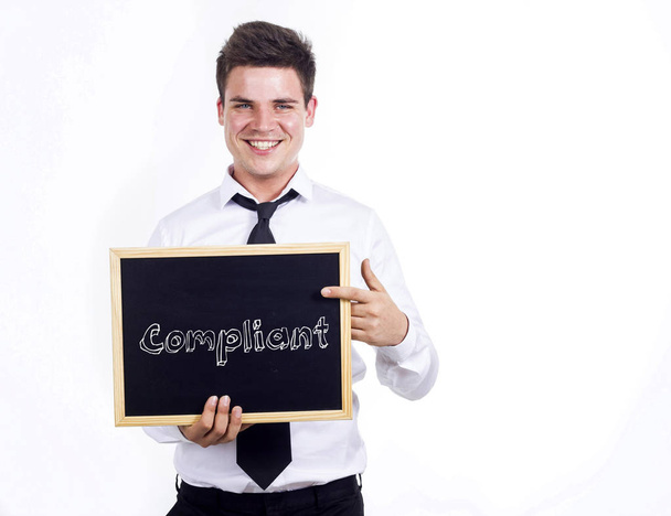 Υποχωρητικός - νεαρός χαμογελαστό επιχειρηματίας κρατώντας Μαυροπίνακας με te - Φωτογραφία, εικόνα