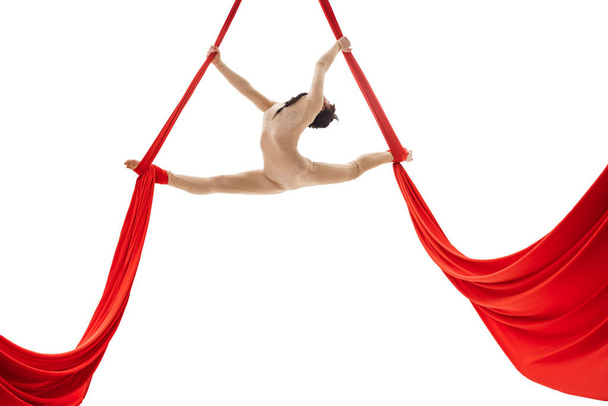 Young girl doing splits on aerial silks in studio - Фото, изображение
