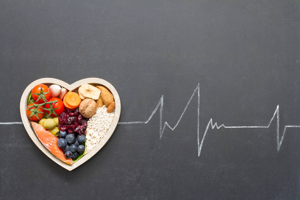 Healthy food in heart and cardiograph on blackboard medical abstract concept - Фото, изображение
