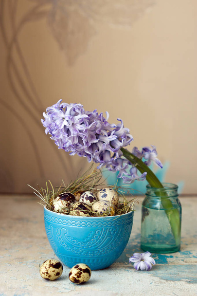 Beautiful Easter composition. Quail eggs in blue bowl and the flower hyacinth. - Фото, зображення