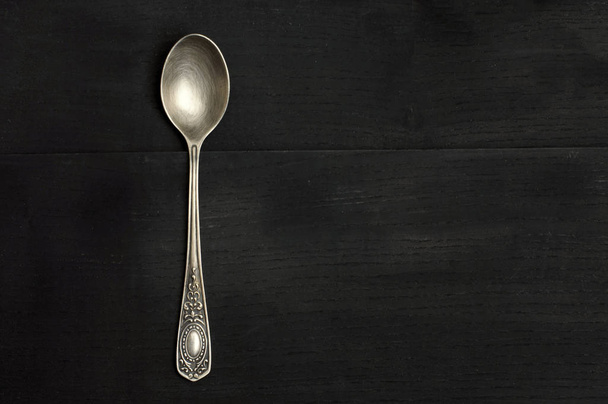 cuchara de plata sobre un fondo negro
 - Foto, imagen