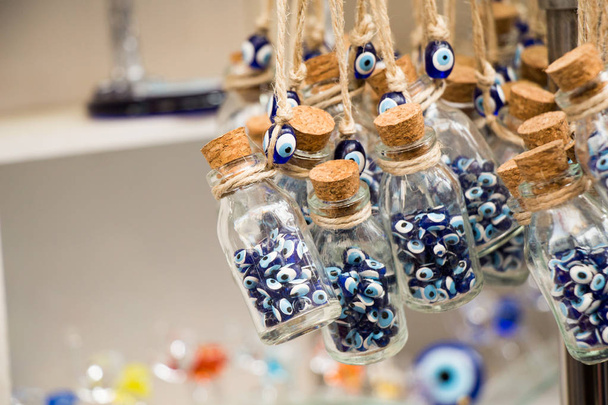kleine transparente Glasflasche gefüllt mit blauen, bösen Augenperlen - Foto, Bild