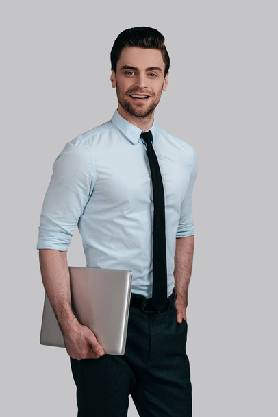 Handsome young man holding laptop - Φωτογραφία, εικόνα