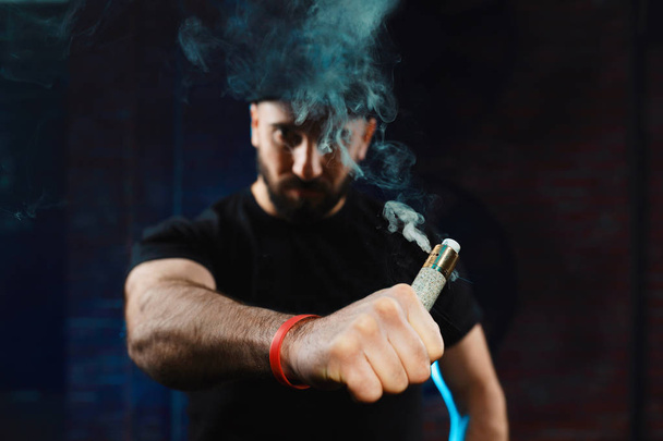Mann verdampft eine elektronische Zigarette - Foto, Bild