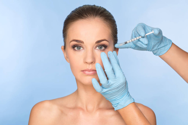 Mujer joven atractiva recibe inyección cosmética de botox. Médicos.
 - Foto, imagen