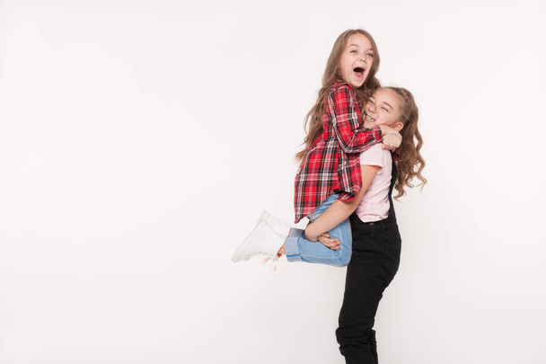 Счастливы две маленькие девочки сестры на белом
 - Фото, изображение