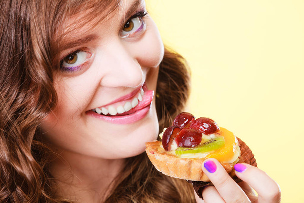 Closeup funny woman eating fruit cake - Foto, afbeelding