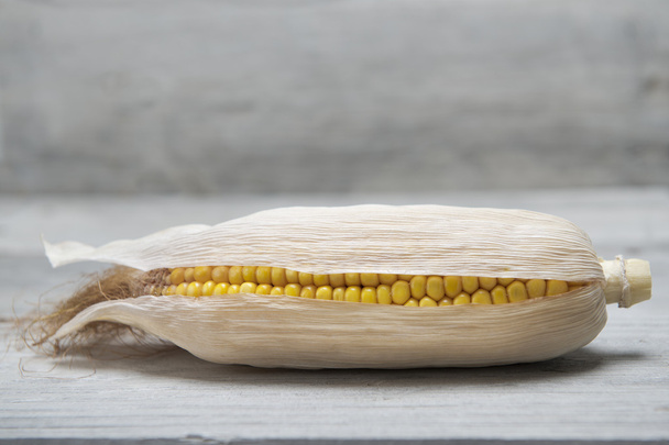 Oreja de maíz sobre fondo de madera
 - Foto, imagen
