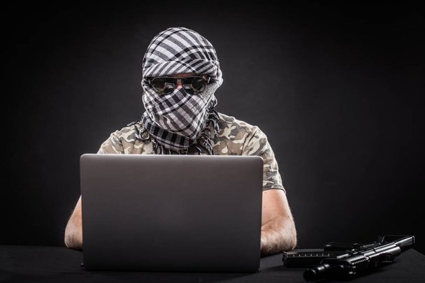 Террорист работает за компьютером. Концепция международного кризиса, войны и терроризма
 - Фото, изображение