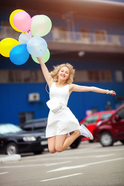 πορτρέτο του όμορφη νεαρή ξανθιά άλματα από ευτυχία κρατώντας τα μπαλόνια - Φωτογραφία, εικόνα