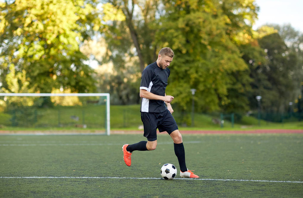 soccer player playing with ball on football field - Fotoğraf, Görsel