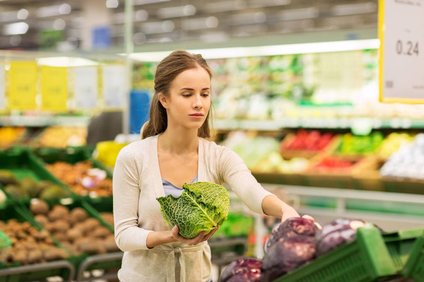 happy woman buying savoy at grocery store - Zdjęcie, obraz