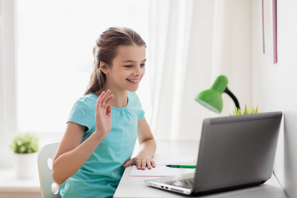 menina feliz com laptop acenando mão em casa
 - Foto, Imagem