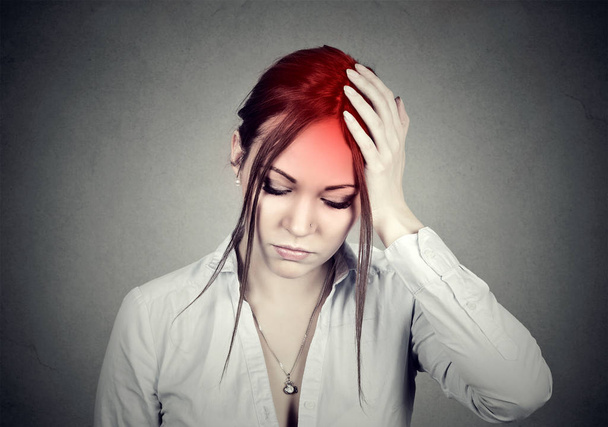 Woman having a headache with her head in her hand  - Zdjęcie, obraz