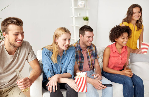 happy friends with popcorn watching tv at home - Foto, Imagem