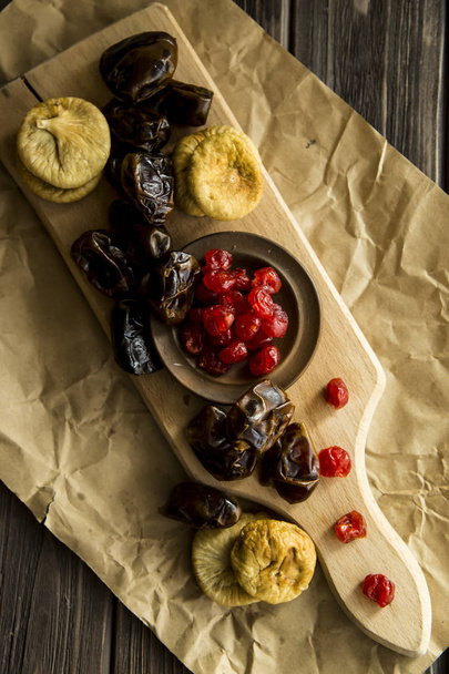 fruta seca na tábua de cozinha - datas, figos e cerejas secas
 - Foto, Imagem