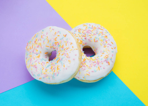 Donuts with icing on pastel colorful background - Photo, Image