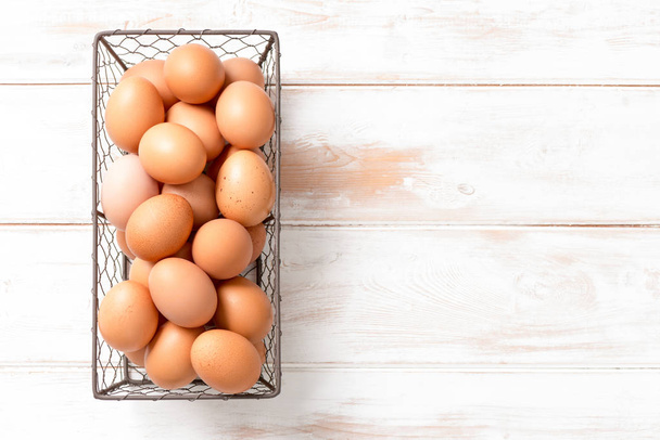 Коричневые куриные яйца в сетчатом подносе с копировальным пространством
 - Фото, изображение