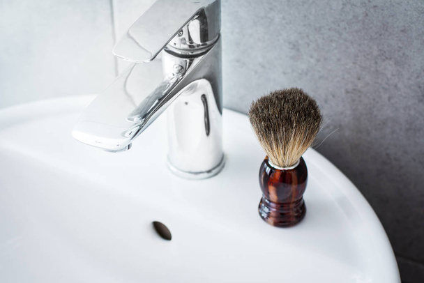 Кисть для бритья на раковине в ванной комнате
 - Фото, изображение