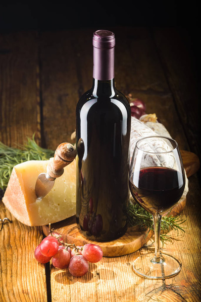 Red wine in vintage light with cheese and fruits. - Photo, Image