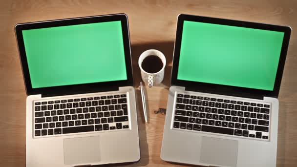Frau trinkt Kaffee im Stehen neben zwei Laptops - Filmmaterial, Video