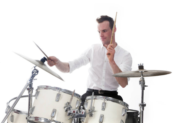 drummer behind drum set wears white shirt and plays the drums - Foto, Bild