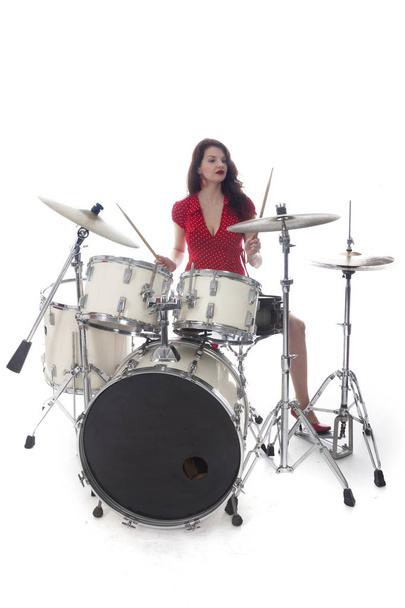 sexy morena en vestido rojo toca batería en estudio
 - Foto, imagen