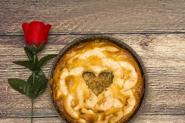 Tarta de manzana con un hueco en forma de corazón en una mesa de madera
 - Foto, Imagen