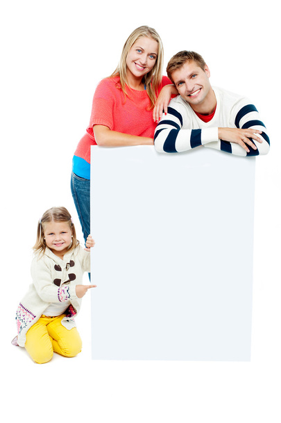 Portrait of happy family presenting blank whiteboard - Foto, Bild
