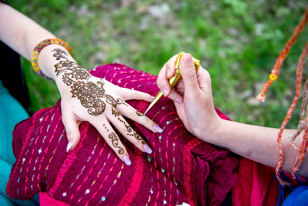 Picture of human hand being decorated with henna tattoo, mehendi - Photo, Image