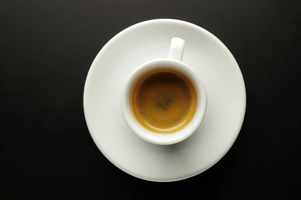 Una taza de café perfumado sobre un fondo negro
. - Foto, imagen