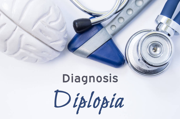 Diplopian diagnoosi. Anatominen aivojen luku, neurologinen vasara ja stetoskooppi makaa paperi- tai kirja otsikolla neurologinen diagnoosi Diplopia. Neurologian käsite
 - Valokuva, kuva