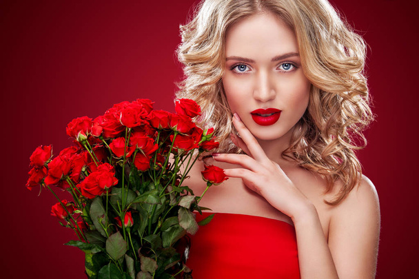 Όμορφη ξανθιά γυναίκα κρατάει μπουκέτο από κόκκινα τριαντάφυλλα. Άγιος Βαλεντίνος και Διεθνές Γυναικείο ημέρα, οκτώ Μαρτίου γιορτή. - Φωτογραφία, εικόνα