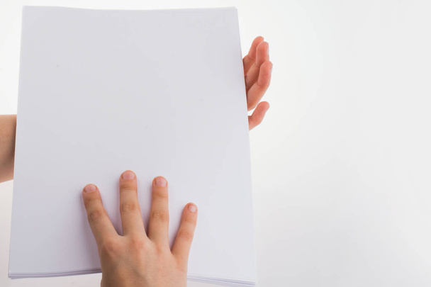 Χέρι που κρατά ένα λευκό κενό φύλλο χαρτιού - Φωτογραφία, εικόνα