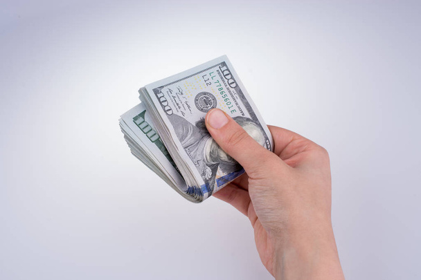 Human hand holding American dollar banknotes on white background - Фото, зображення