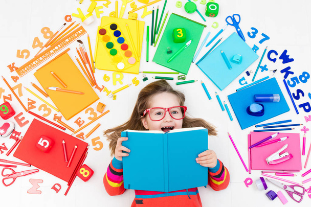 Child with school and drawing supplies. Student with book. - Foto, Imagen