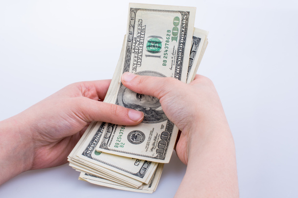 Ludzka ręka trzyma banknotów dolara amerykańskiego na białym tle - Zdjęcie, obraz