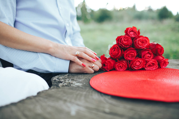 a menyasszony és a vőlegény jegygyűrűt közelében a virágok a kezében - Fotó, kép