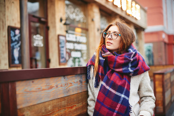 Menina em óculos e lenço cobertor com célula escocesa
 - Foto, Imagem