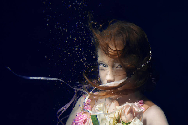 portré, fiatal, gyönyörű, vörös hajú lány rózsaszín ruha és víz alatti rózsákkal - Fotó, kép