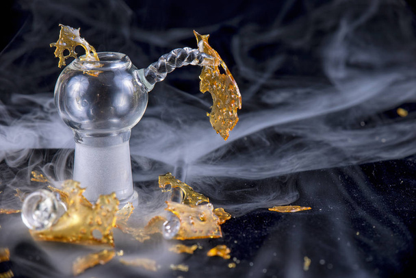 Marijuana oil concentrate aka shatter isolated with glass rig on - 写真・画像