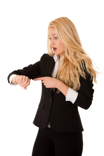Portrait of shocked young woman holding hand with wrist watch and looking at camera isolated on a white background. - Photo, Image