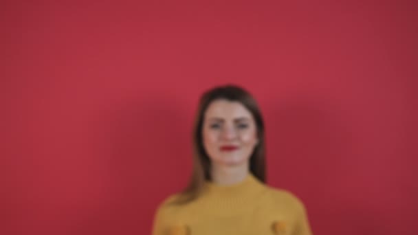 Close up portrait beautiful young woman at studio on red wallpaper - Felvétel, videó