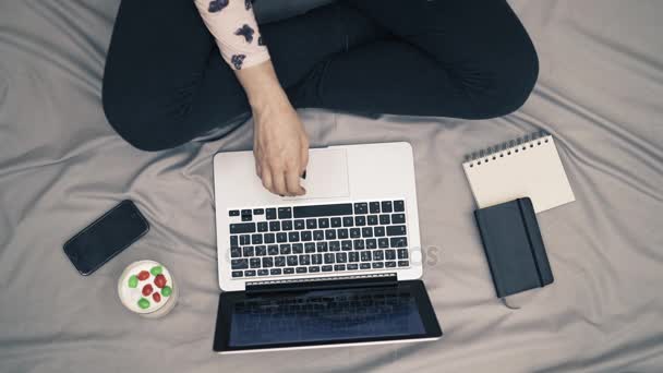 Top view shot of woman in bed, feet , laptop and yogurt on the gray blanket - Metraje, vídeo
