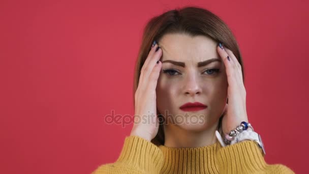 Young blonde woman having a headache, studio portrait. Woman putting hands on head, isolated on dark background. Concept of problems and headache. - Footage, Video